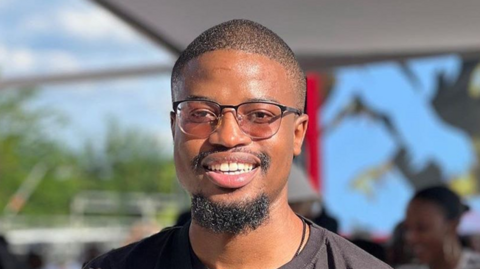 A man wearing sunglasses and a black shirt