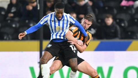 Sheffield Wednesday forward Ike Ugbo jostling for the ball with Hull City's Charlie Hughes.