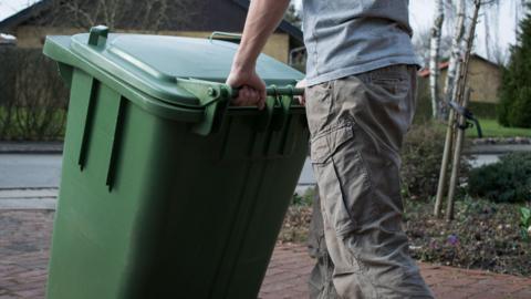 Man taking out wheelie bin