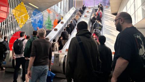 People queue to get up escalator at Tottenham Court Road station
