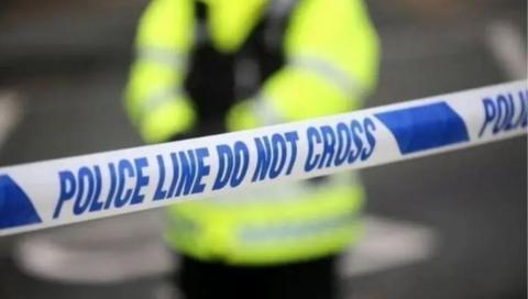 A stock image showing a police cordon and a police officer stood inside the cordon. 