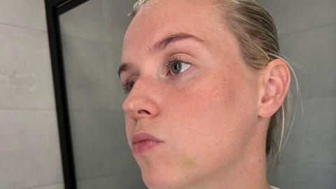 PC Wood has dyed blonde hair in a bun