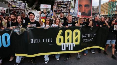 Relatives and supporters of Israeli hostages held captive in the Gaza Strip since October 7 hold their portraits during a protest at Hostages Square in Tel Aviv on 28 May 2025.