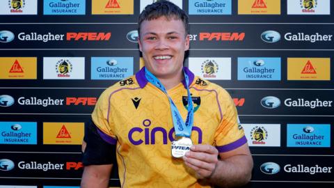Tom Litchfield holding his man of the match medal