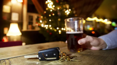 A pint of beer next to a set of car keys