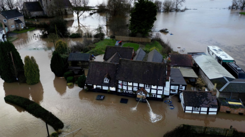 Aeriel view of the village of Severn Stoke surrounded by muddy flood water
