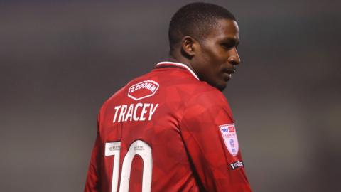 Shilow Tracey with his back to the camera and his number 10 on his shirt walks away and prepares for the game to restart