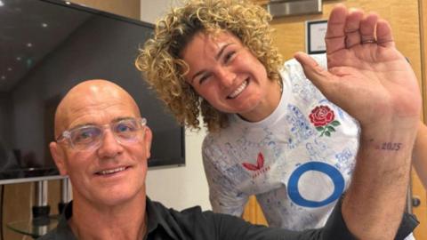 John Mitchell shows off his tattoo