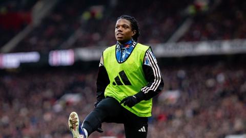 Manchester United defender Tyrell Malacia warms up during the Premier League victory over Fulham