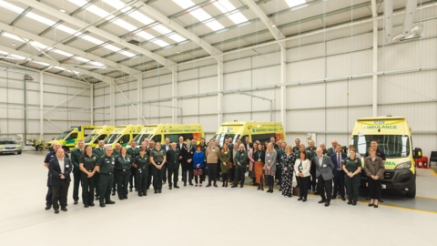 A large group of people gathered in front of ambulances in the new facility for the ambulance service in Ferndown. 