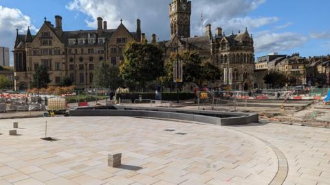 Bridge Street meeting place development, an open paved area with work ongoing behind it 