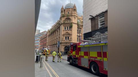 Fire crews outside an ornate four storey building on an urban street