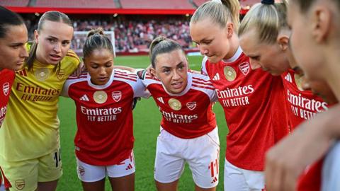 Katie McCabe of Arsenal talks with teammates in a huddle 