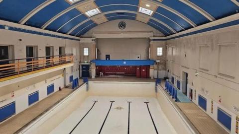An empty swimming pool with blue and white paint