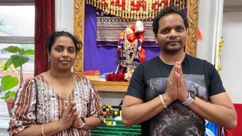 Satish Kumar Divvela (L) and Annapurna Divvela (R) they are behind a Hanuman statue. 