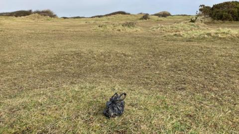 Penhale dunes with a small black plastic bag tied up