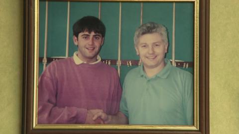 A teenager Ronnie O'Sullivan shakes the hand of snooker cue manufacturer John Parris in an old photograph on a wall at Parris Cues