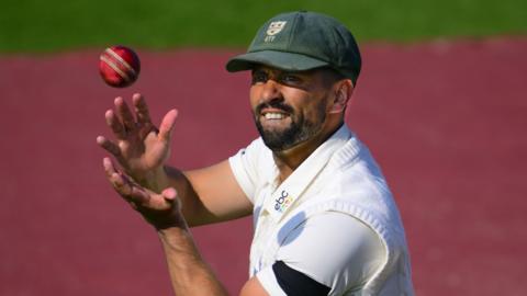 Yadvinder Singh, wearing a Worcestershire green cap, catches the ball in the field