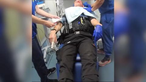 Police officer unconscious in hospital.