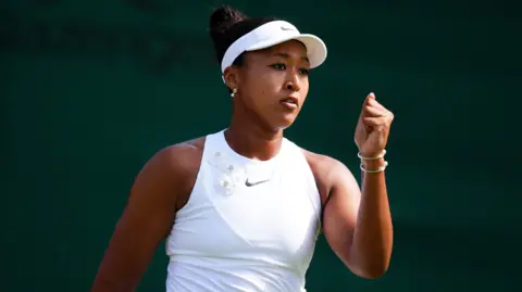 Naomi Osaka celebrates with a clenched fist