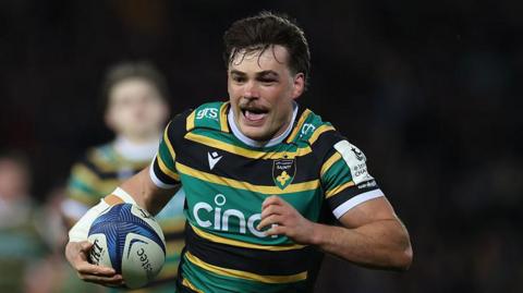 George Furbank running with his tongue out on the way to score for Northampton Saints.