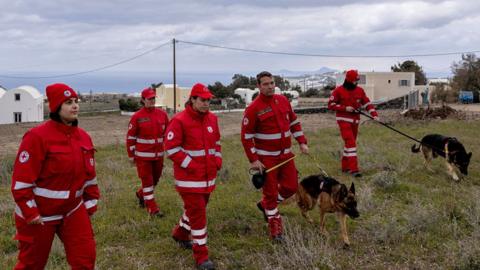 Red Cross rescuers with rescue dogs map the area, as the increased seismic activity continues on the island of Santorini, Greece, on 8 February 2025.