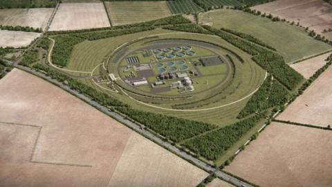 An aerial view of an artist's impression of a new waste treatment works in Cambridge. A circular area of land can be seen with grey buildings inside, surrounded by grass and trees. Beyond the perimeter are empty fields. 
