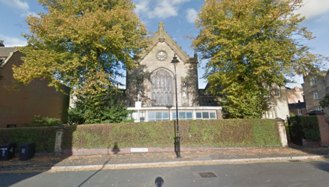 A building with a gabled roof and a stained-glass window
