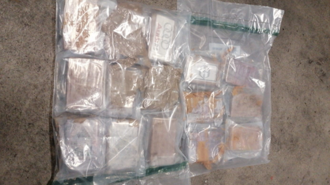 A clear ziplock bag with a number of brown packets inside.