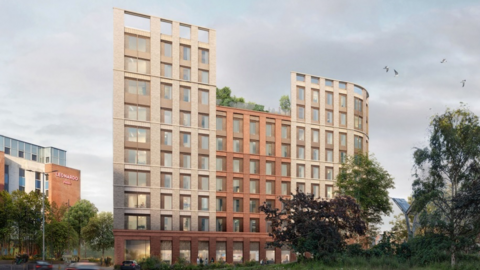 The architect’s visualisation shows a modern, newly designed building with a gentle curve at each end and a mixture of light and reddish brick. It rises to about 10 storeys and has large, evenly spaced windows. The top levels include greenery, with trees and plants set back from the outer walls, giving the impression of a rooftop garden. 