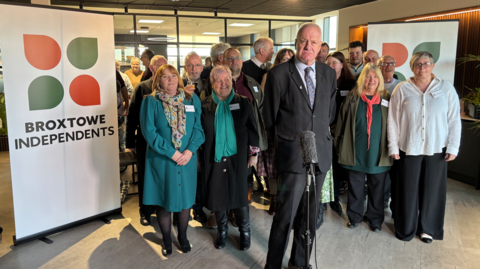 A group of Broxtowe Borough Councillors standing next to a white sign that says Broxtowe Independents