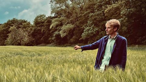 Charlie Cooper stands in a field in 'Local Legends' series