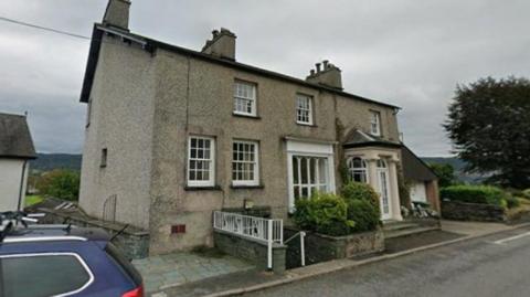 Wraysdale House. It is a pebble-dashed residential-looking building with steps leading down to the GP surgery.