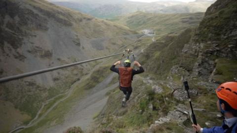 Person riding a zip wire in Lake District