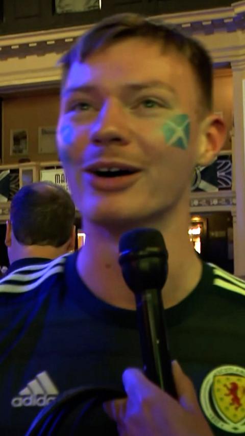 Man in blue Scotland top with short hair and Scotland flag on his cheek