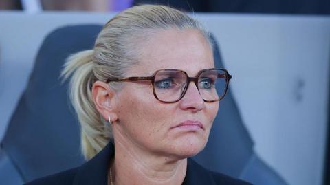 Sarina Wiegman looks forward with a fixed expression