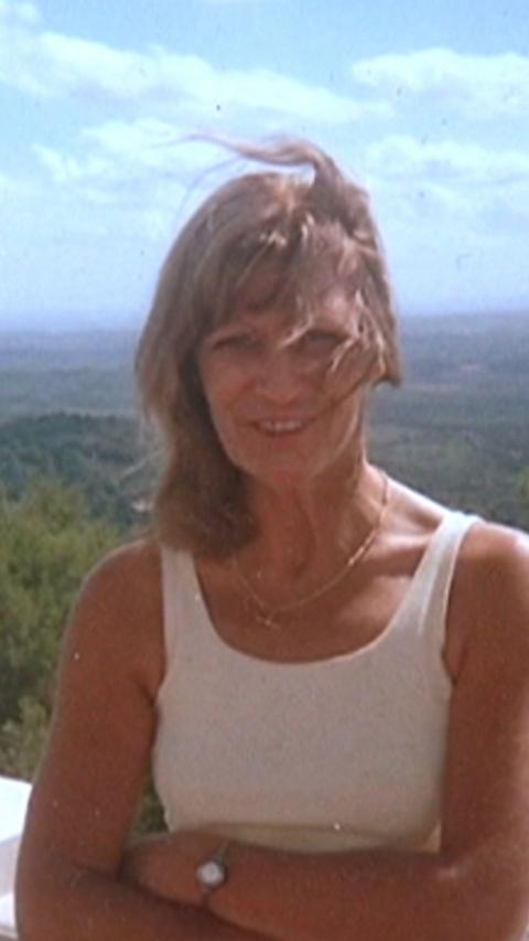 A woman with long blond hair and with sleeveless top