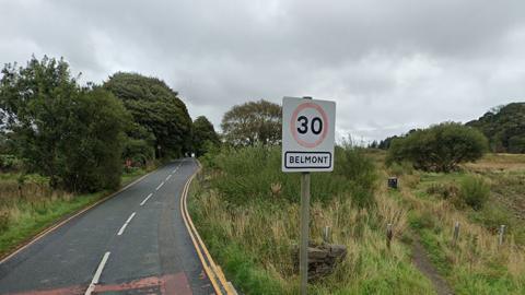 Street view of Rivington Road in Belmont, a country road surrounded by fields