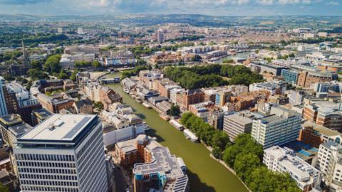Drone view of the city of Bristol, captured above Feeder Road, showing a green-coloured River Avon dividing the north and south of the city.