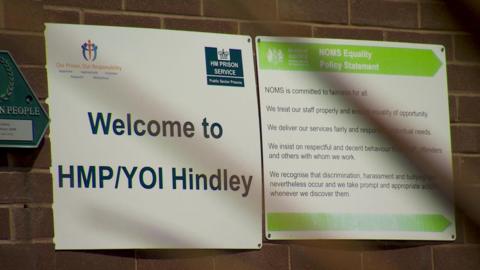 A sign for HMP/YOI Hindley on a brick wall inside the jail 