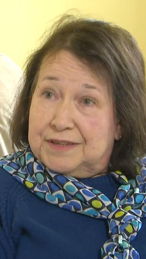 A woman with short brown hair in a blue top.