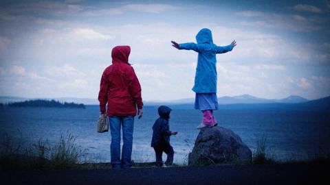 A mother with her two children by the sea