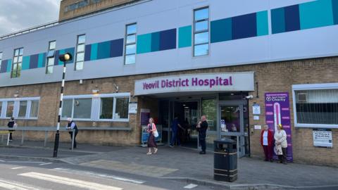 The front entrance of Yeovil District Hospital. A few people are outside.