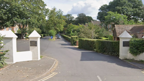 Google street view of Phyllis Court Drive in Henley. It appears to be a private road, with the entrance between two white pillars.