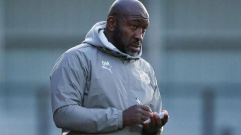 Darren Moore makes notes during a Port Vale match