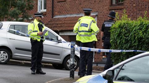 Police officers outside a property.