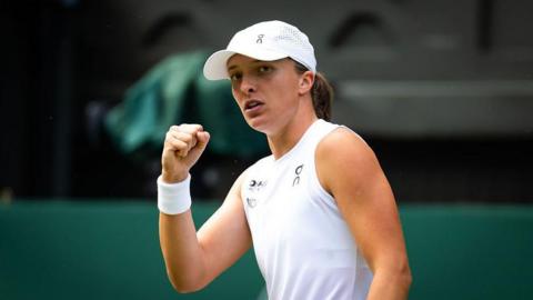 Iga Swiatek celebrates winning a point by clenching her fist 