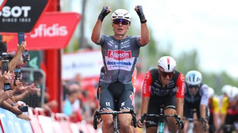 Jasper Philipsen raises his fists in celebration