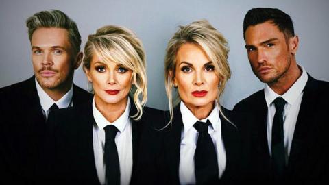 The four members of The Fizz wearing black jackets and ties and white shirts