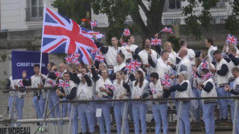 Team GB athletes wave from a boat sailing down the River Seine at the 2024 Paris Olympic Games opening ceremony